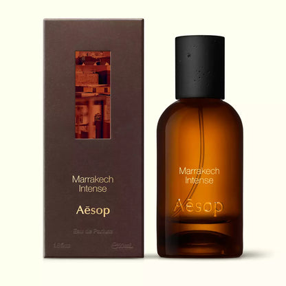Amber glass Aesop Marrakech Intense Eau de Parfum bottle beside its brown outer box on a white background.