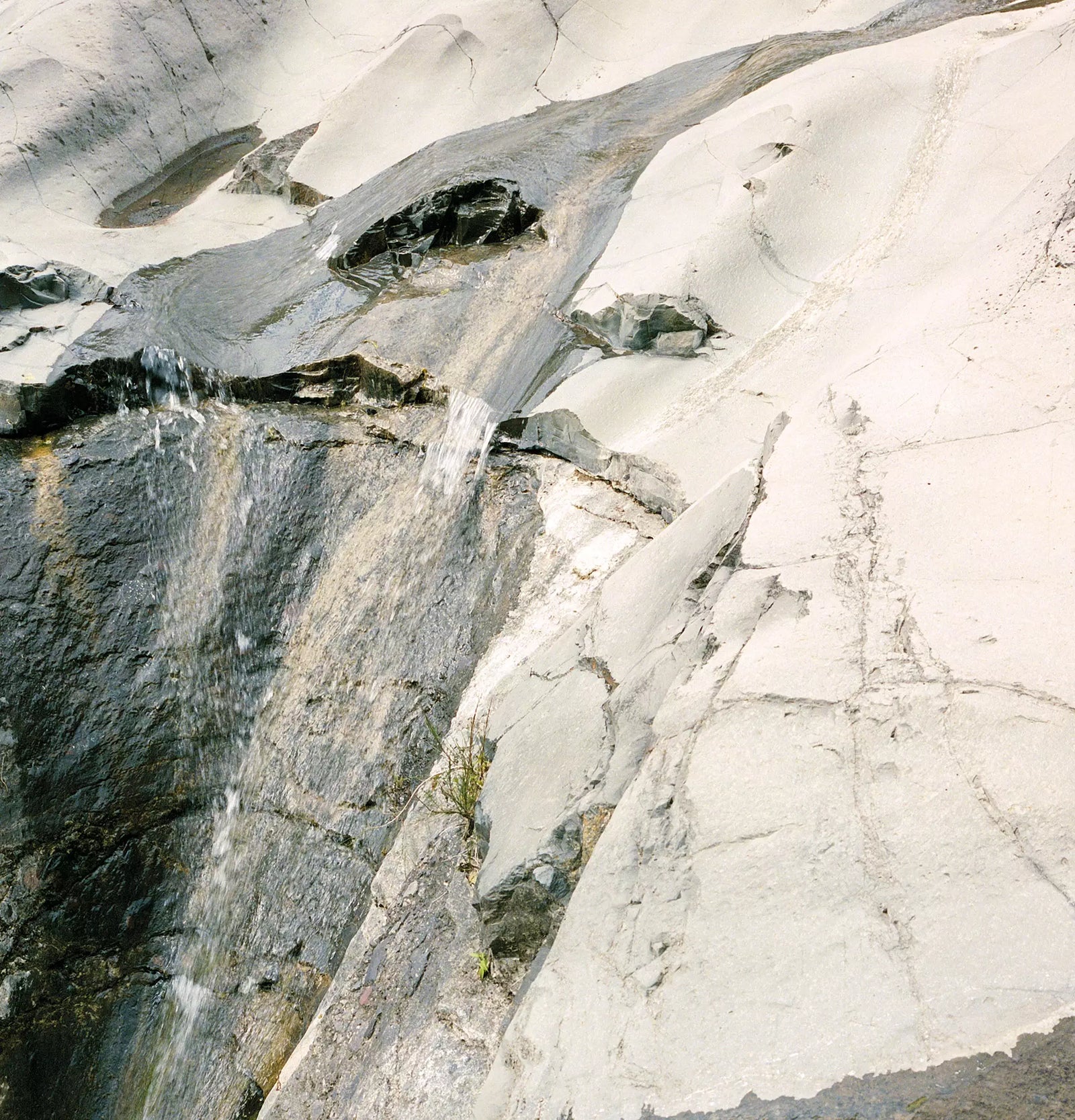 Close-up of a pale stone surface with grey and dark veining.