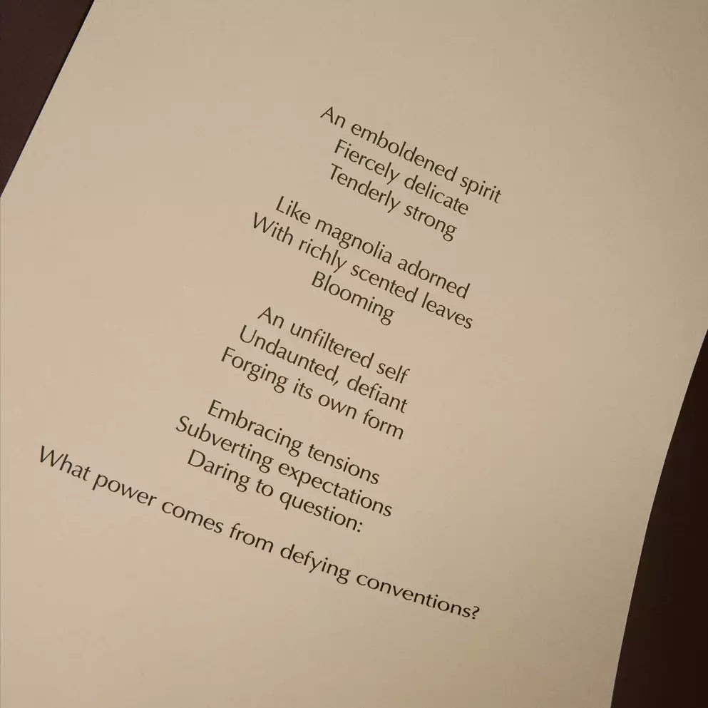 Curved cream page with printed verse against a dark brown background.