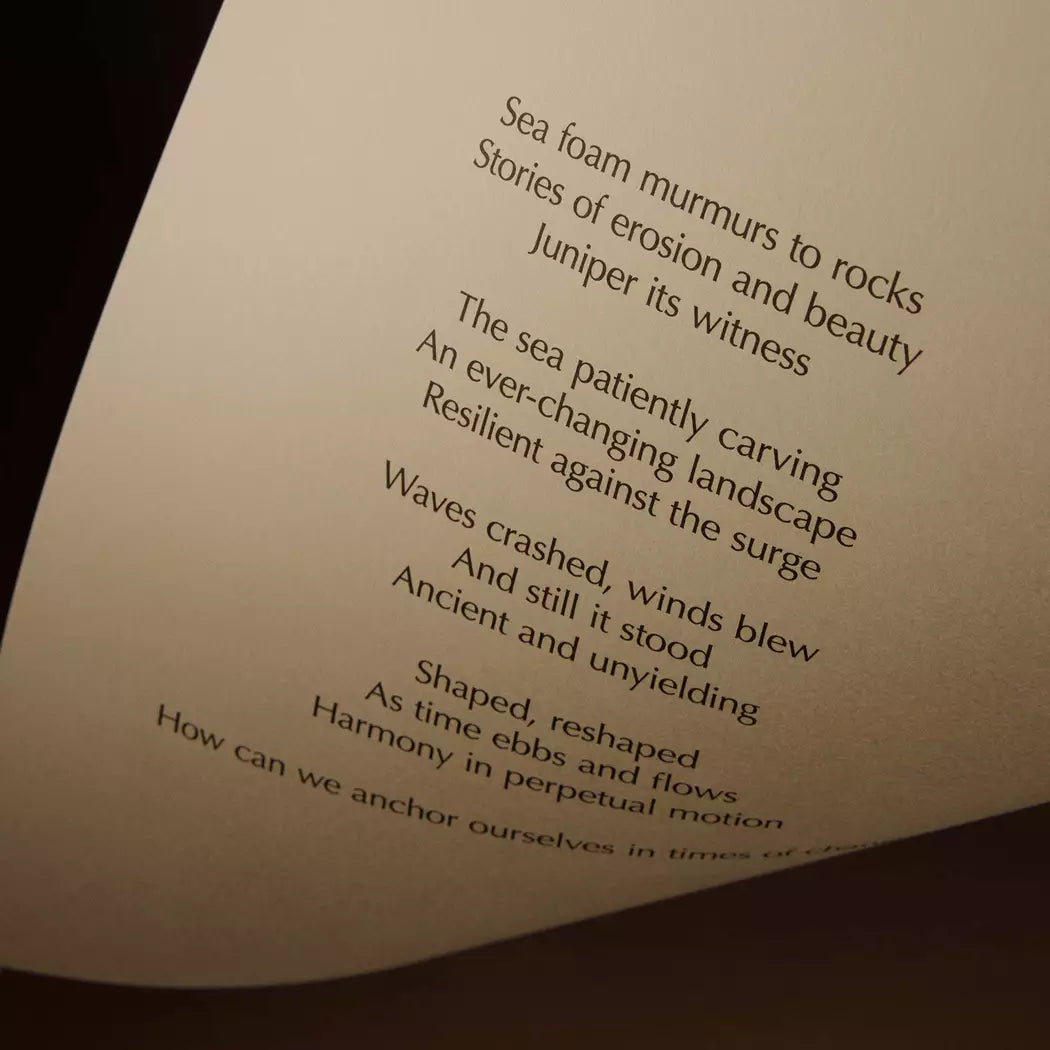 Curved cream page with printed verse against a dark brown background.