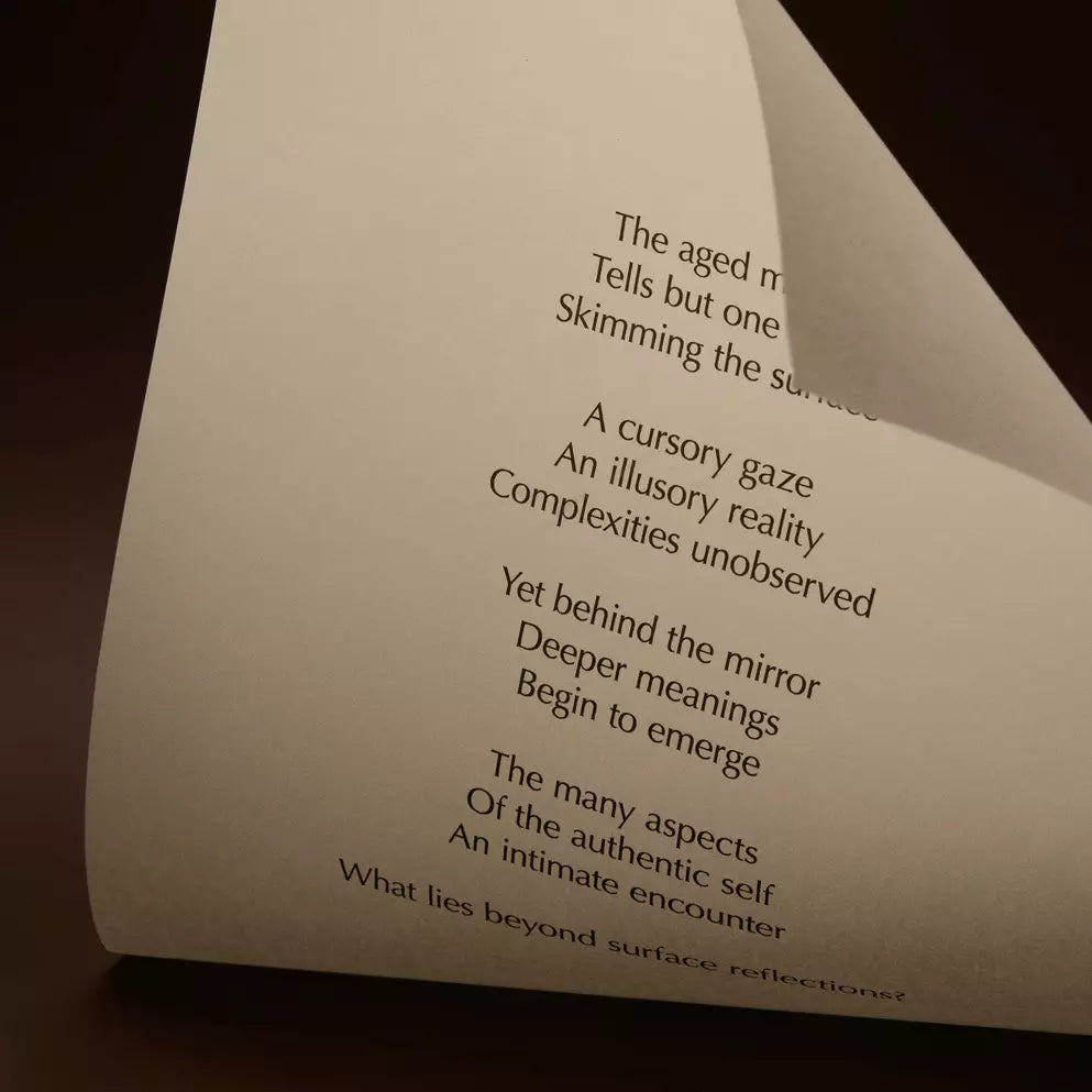 Curved cream page with printed verse against a dark brown background.