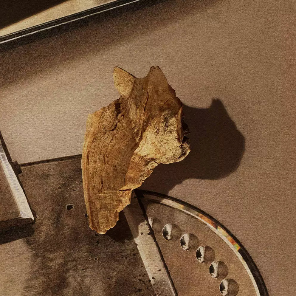 Piece of wood resting on stacked mirrored trays.