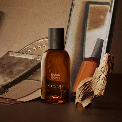 Aesop Evoking Eidesis bottle with a tube and piece of wood on mirrored trays.