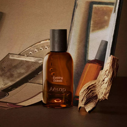 Aesop Evoking Eidesis bottle with a tube and piece of wood on mirrored trays.