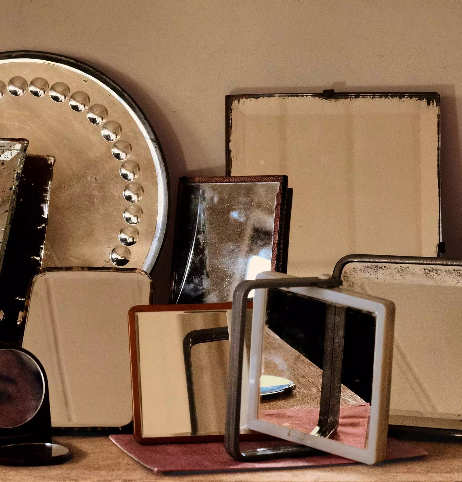 Close-up of stacked mirrored trays with warm reflections.