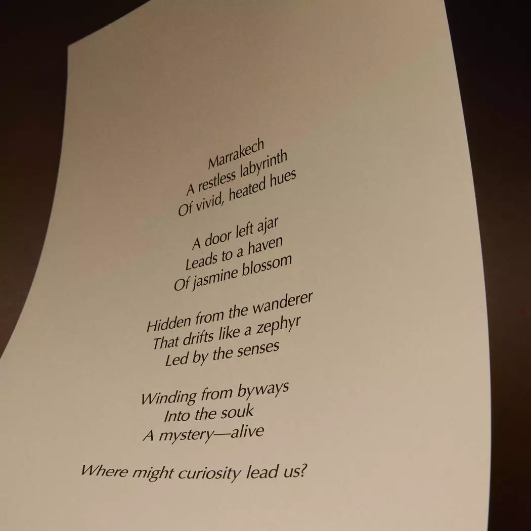 Curved cream page with printed verse against a dark brown background.