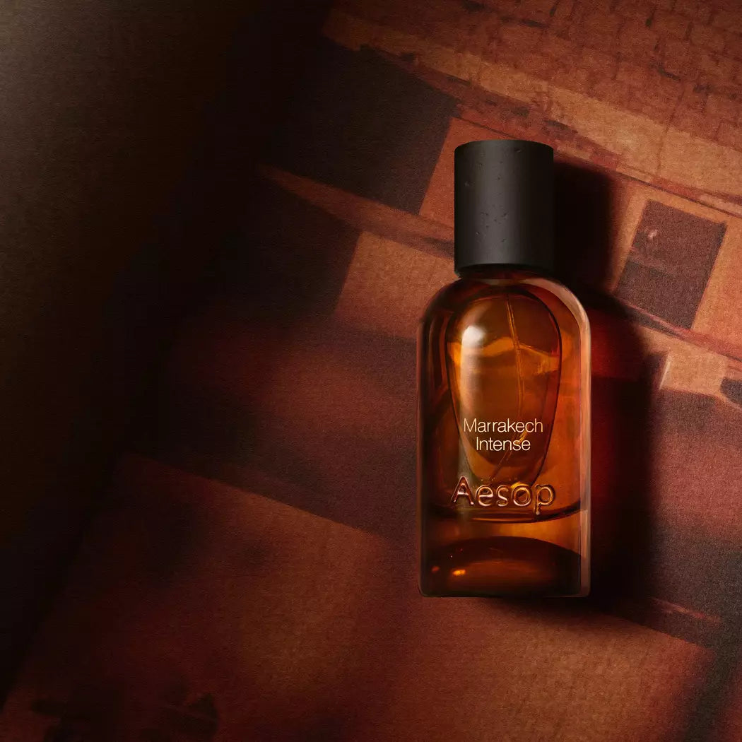Aesop Marrakech Intense bottle in warm shadow against a textured brown backdrop.