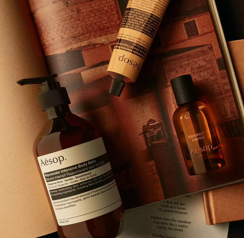 Aesop Marrakech Intense bottle with pump bottle and yellow tube arranged on warm-toned papers.