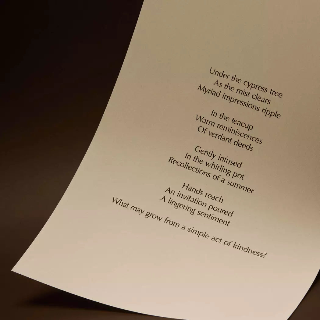 Curved cream page with printed verse against a dark brown background.