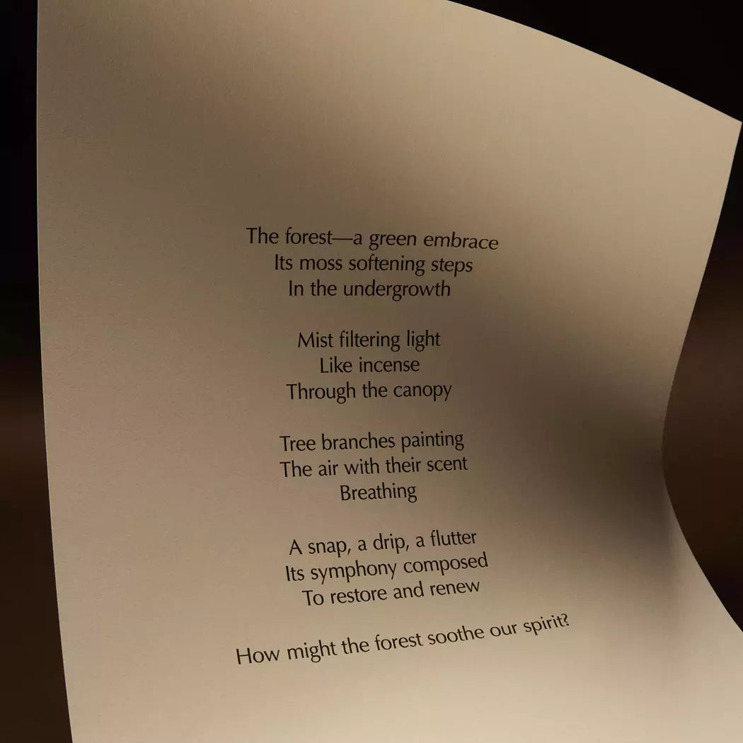 Curved cream page with printed verse against a dark brown background.