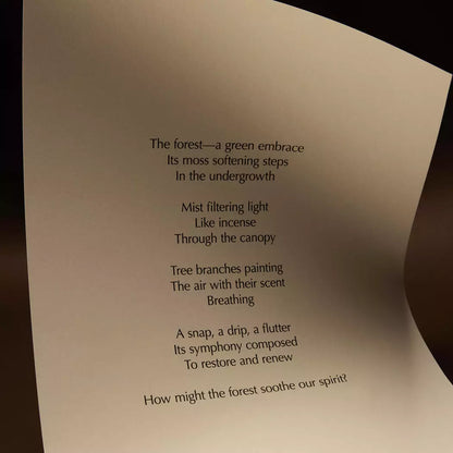 Curved cream page with printed verse against a dark brown background.