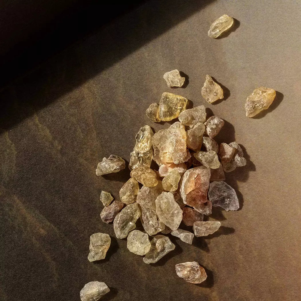 Close-up of resin stones scattered on a dark surface.